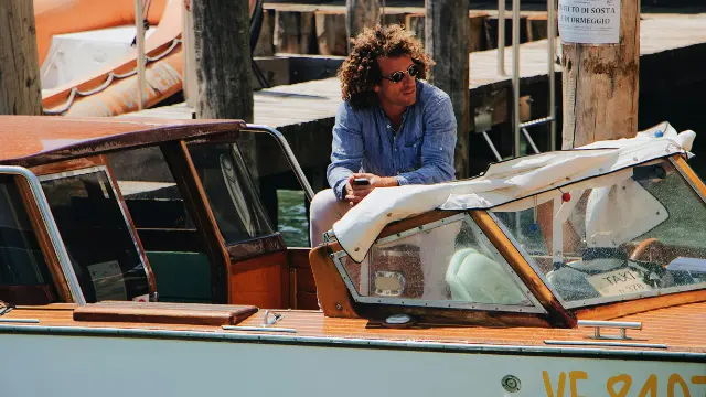 Hombre joven descansando en una lancha en Venecia, representando libertad y planificación para el retiro
