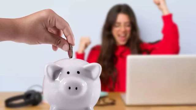 Mujer feliz frente a su laptop mientras una mano deposita una moneda en un piggy bank, simbolizando el ahorro para el retiro.