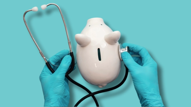 Doctor’s hands with a stethoscope over a piggy bank, representing the financial impact of medical expenses.