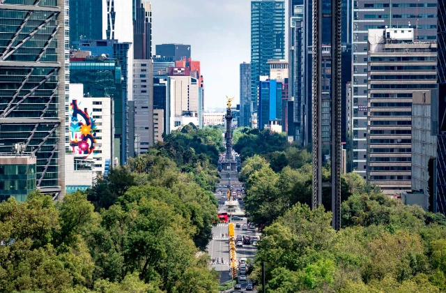 Paseo de la Reforma avenue in Mexico City with skyscrapers and traffic during the day.