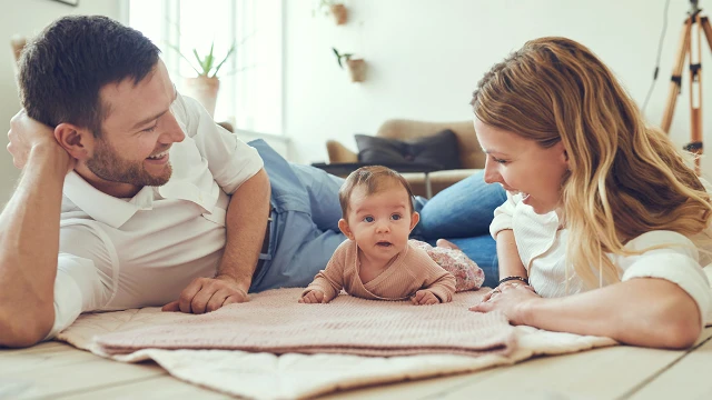 A happy mother and father with their baby, representing maternity health insurance and family medical coverage for expats in Mexico.