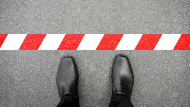 Zapatos de vestir frente a una línea que representa el tope de coaseguro en un seguro de gastos médicos.