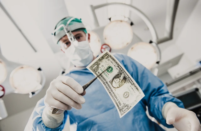 Cirujano sosteniendo un billete con unas pinzas durante una operación, representando el deducible en un seguro de gastos médicos.
